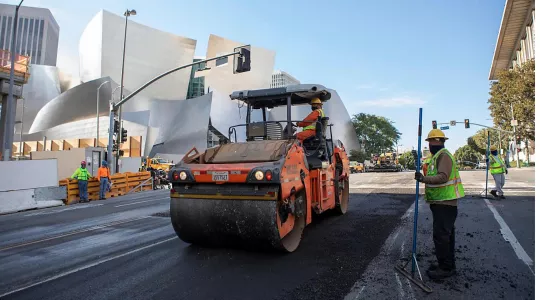 Recycled plastic asphalt paving underway on 1st street with Disney theater in background
