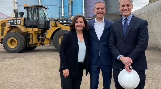 Commissioner Teresa Villegas Mayor Eric Garcetti and Board of Public Works President Greg Good in front of a bulldozer and silos at an asphalt plant 