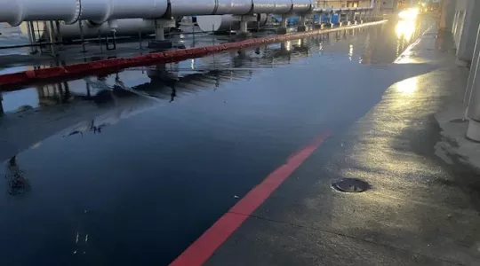 Sewage pipeline at Hyperion plant with floodwater below on the pavement