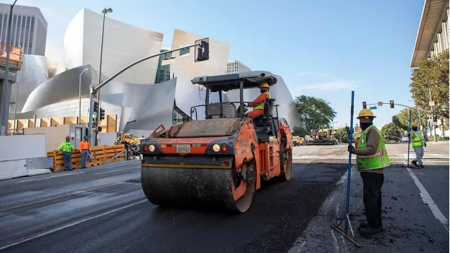 Recycled plastic asphalt paving underway on 1st street with Disney theater in background